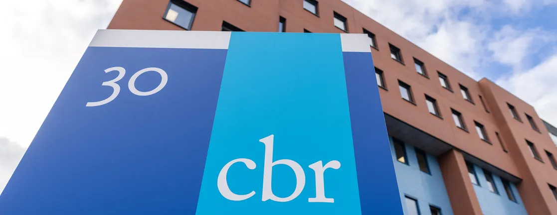 Het CBR-logo op een blauw bord voor een examencentrum van baksteen