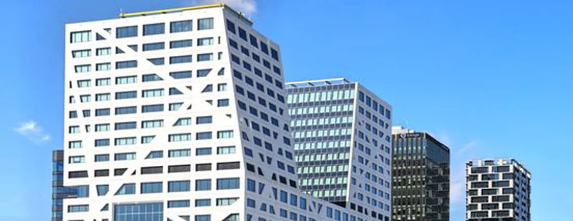 Het stadskantoor van Utrecht: een hoog wit gebouw met onregelmatige ramen tegen een blauwe lucht